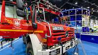 Feuerwehrauto Ein Feuerwehr-Unimog mit geöffneter Tür vor einem Messestand