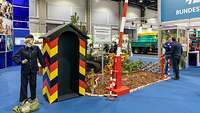 Eingang zum Bundeswehr-Stand auf der IGW 2023 Stand der Bundeswehr auf der Internationalen Grünen Woche mit Schaufensterpuppe in Marineuniform, Schlagbaum und Wachhäuschen.
