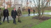 Verteidigungsminister Pistorius läuft gemeinsam mit anderen Personen und Soldaten im Wald der Erinnerungen im EFK.