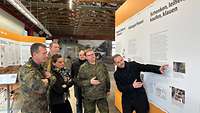Drei Soldaten und drei Zivilisten stehen vor den neuen Informationstafeln.