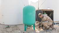 Wassertankstation Ein Soldat entnimmt eine Wasserprobe an einer Wassertankstation