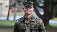 Ein Soldat in Flecktarn lächelt in die Kamera