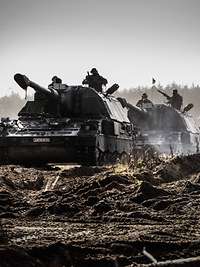 Drei Panzerhaubitzen 2000 fahren hintereinander im Gelände