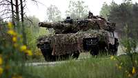 Ein getarnter Kampfpanzer vom Typ Leopard 2 A4 NO fährt im Gelände