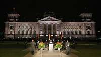 Eine Formation vor dem Reichstag bei Nacht.