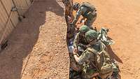 Drei litauischen Soldaten versorgen Verwundete.