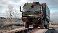Ein Lkw überfährt langsam eine Kriegsbrücke.