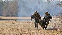 Zwei Bundeswehrsoldaten tragen einen Kameraden