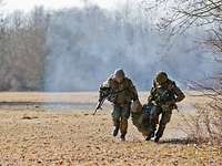 Soldaten tragen einen verletzten Kameraden bei einen einsatznahen Gefechtssituation im Rahmen einer Sanitätsübung. Zwei Bundeswehrsoldaten tragen einen Kameraden