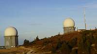 Auf einem Bergkamm befinden sich zwei Radarstationen unter einer Kuppel, die sich in gewissen Abstand zu einander befinden