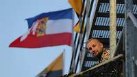 Soldat posiert vor der Landesflagge von Schleswig-Holstein.
