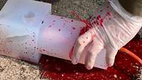 In Nahaufnahme drückt ein Soldat den behandschuhten Finger in eine simulierte Schusswunde um die Blutung zu stoppen.
