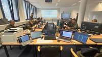 Ein Raum mit vielen Computern, in dem mehrere Soldaten und Soldatinnen arbeiten.