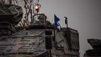 Ziel in Sicht Aus einem fahrenden Radpanzer mit orangefarbenen Rundumleuchten blickt ein Soldat.