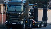Der eigene Abschleppwagen Ein Lastkraftwagen mit Tiefladefläche steht neben einer Halle.
