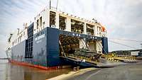 Soldaten verladen LKW auf ein Schiff
