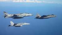 Drei graue Kampfjets fliegen in lockerer Formation.