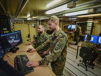 Luftbildaufklärung auf dem Fliegerhorst Jagel Zwei Soldaten arbeiten im Stehen an einem Computer, auf dem Luftbildaufnahmen zu sehen sind.