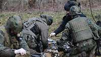 Mehrere Soldaten kümmern sich um verletzte Kameraden
