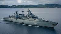 Eine Fregatte der deutschen Marine durchquert norwegische Gewässer. Im Hintergrund sind Berge zu sehen. 