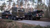 Mehrere Militärfahrzeuge in einem Wald.