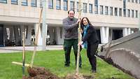 Eine Frau und ein Mann pflanzen einen Baum