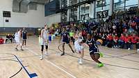 Eine Spielerin dribbelt zum Korb