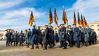 Soldaten mit Fahnen marschieren in Formation