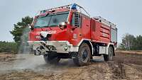 Ein Feuerfahrzeug in einen dünnen Wassernebel gehüllt