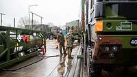 Zwei Soldaten betanken mehrere Bundeswehr-Fahrzeug