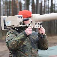 Der Feldjäger hält den schultergestützten Effektor in der Hand und visiert eine Drohne an.