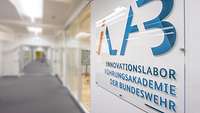 Ein Schild mit dem Text "Innovationslabor der Bundeswehr" hängt an der Wand.