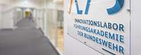 Ein Schild mit dem Text "Innovationslabor der Bundeswehr" hängt an der Wand.