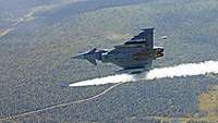 Ein Eurofighter fliegt senkrecht und schießt einen Lenkflugkörper ab