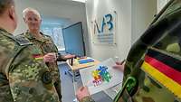 Drei Soldaten stehen vor dem Logo des Innovationslabor. Einer hält einen Zettel in der Hand.