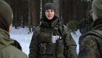 Eine litauische Soldatin unterhält sich mit zwei weiteren Soldaten.