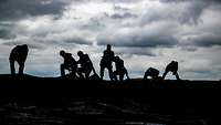 Soldiers on a hill against the light