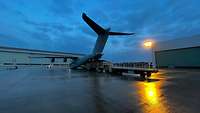 Ein A400M steht in der Dämmerung auf einem Flugfeld.