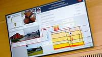 Großer Flachbildschirm an Wand mit Informationen und Grafiken