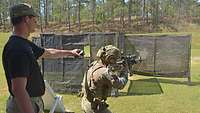 Ein amerikanischer Soldat schießt mit seinem Gewehr auf Scheiben, eine Hülse fliegt durch die Luft.