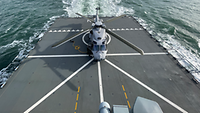 Markings on the landing pad A helicopter is standing on the landing pad of a large vessel. There are landing markings on the landing pad.