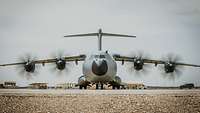 Ein Transportflugzeug A400M mit rotierenden Propellern auf einem Rollfeld