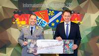 Zwei Männer halten symbolisch das Ticket zum Garnisonsball in die Kamera.