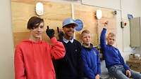 Vier Schüler zeigen auf einen selbst montierten Schaltkreis in einer Elektro-Werkstatt