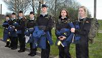 Junge Mädchen stehen nebeneinander in blauer Uniform
