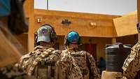 Mehrere Soldaten laufen auf ein Gebäude zu. An dessen Mauern prangt ein blauer Stern.