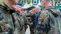 Soldatinnen und Soldaten erhalten Glückwünsche durch Militärs und Zivilisten