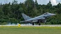 Ein Eurofighter landet auf einer Landebahn. 