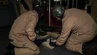 Soldaten beim Bau einer Leckabdichtung mittels Holzes, Hammer und Nägeln.
