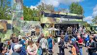 Menschen stehen bei Sonnenlicht vor dem aufgebauten Karrieretruck 